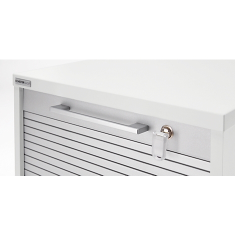 Gros plan sur un meuble de bureau blanc avec des lattes horizontales et une barre de poignée argentée. Clé dans la serrure.