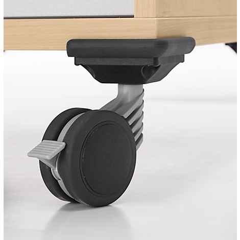 Gros plan d'un pied de roulette fixé sous un meuble en bois clair. Le pied est en plastique noir avec un levier de verrouillage gris.