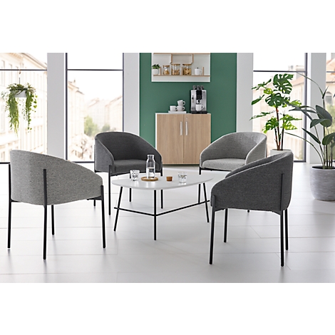 Four grey armchairs around a white table. In the background a sideboard and plants.