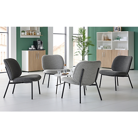 Four gray chairs surround a small table with glasses and a water bottle. Cabinets in the background.