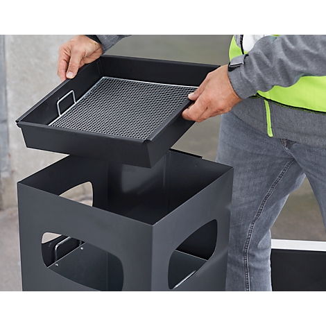A person lifts out a black bin insert. The bin is also black and angular.