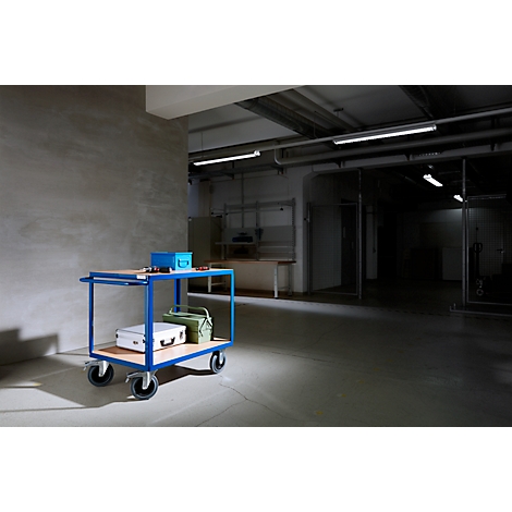 Blue service cart with tools and suitcases in a warehouse.