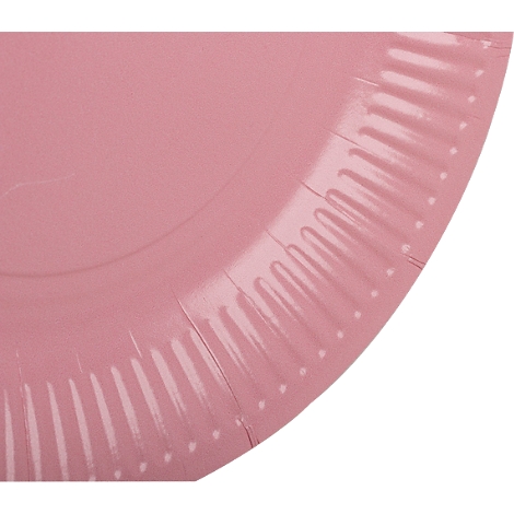 Gros plan sur un coin d'assiette en papier rose, avec un bord cannelé.