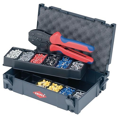 Mallette à outils noire avec couvercle ouvert, remplie d'une pince à sertir, d'embouts et de cosses isolées.