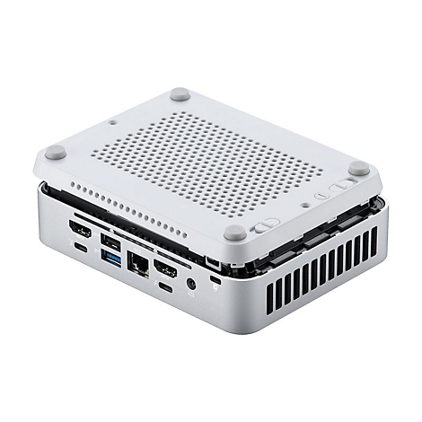 Grauer Mini-PC, Deckel teilweise geöffnet, zeigt Lüftungsgitter und Anschlüsse. Hellgraue Füße und Tasten. Hintergrund weiß.