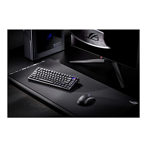 Schwarze Gaming-Tastatur, Maus und Monitor auf dunkler Tischplatte. Leuchtende blaue Tasten und ein ROG-Logo sind erkennbar.