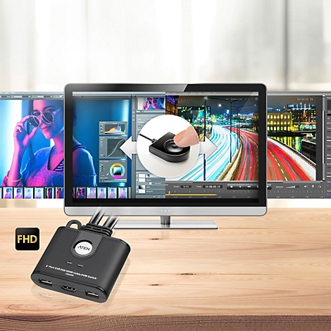 KVM-Switch CS22HF vor einem Monitor mit Videobearbeitungssoftware und Fernbedienung im Fokus.