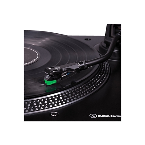 Nahaufnahme eines Plattenspielers mit schwarzem Tonarm und grünem Tonabnehmer auf einer Vinylplatte.