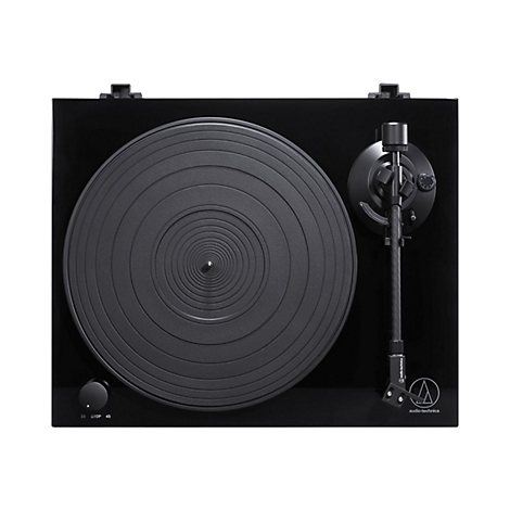 Schwarzer Plattenspieler mit runder Platte und Tonarm. Auf der Platte sind konzentrische Kreise zu sehen. Marke: Audio-Technica.