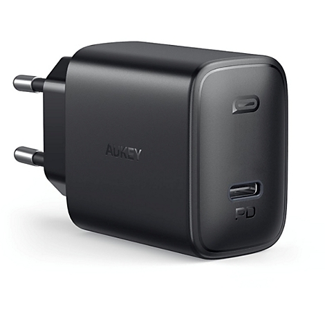 Un adaptateur secteur Aukey noir. Il possède deux ports USB-C et deux broches pour la prise de courant.