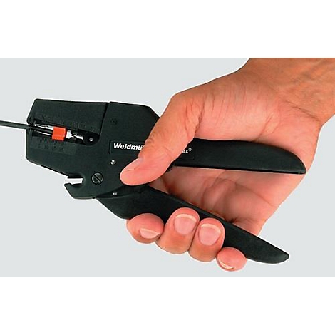 Hand houdt een zwarte draadstripper vast; een draad wordt gestript.