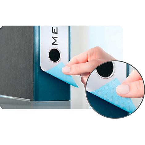 A hand peels a blue label from a blue folder labeled "ME". Magnified detail of the label.