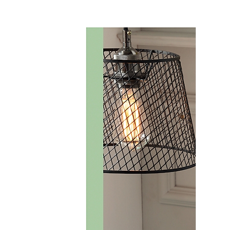 Close-up of a decorative pendant lamp with wire mesh shade and glowing light bulb.