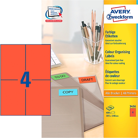 Close-up of Avery labels with a sheet of labels and labeled folders lying on a desk.
