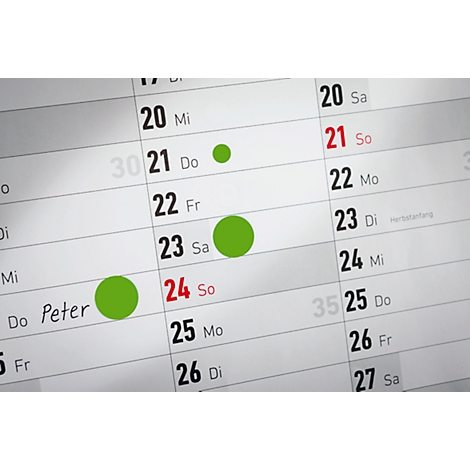 Nahaufnahme eines Kalenders, mit grünen Kreisen auf den Daten 21, 23 und 24 markiert.