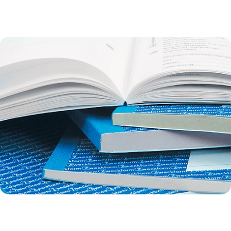 Open book with visible text, stacked on books with blue spines. A stack of books in the background.