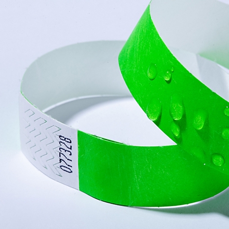 Een felgroene polsband met waterdruppels op een witte ondergrond. Het woord watervast staat eronder.