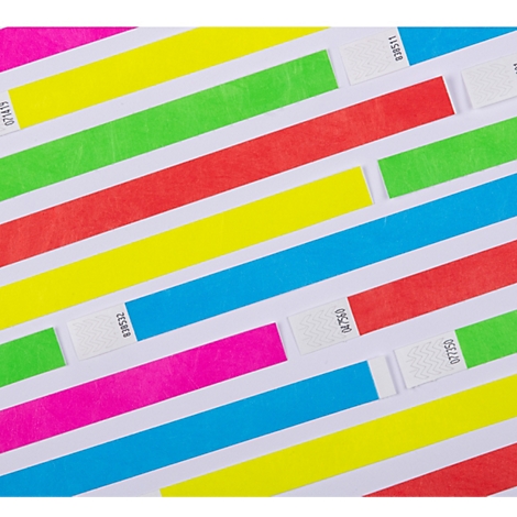 Meerdere kleurrijke neon polsbandjes liggen verspreid over een witte achtergrond.
