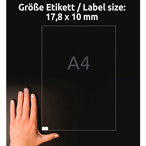 An A4 sheet lies on a dark background, next to a hand. The text "Größe Etikett / Label size: 17.8 x 10 mm" is shown above.