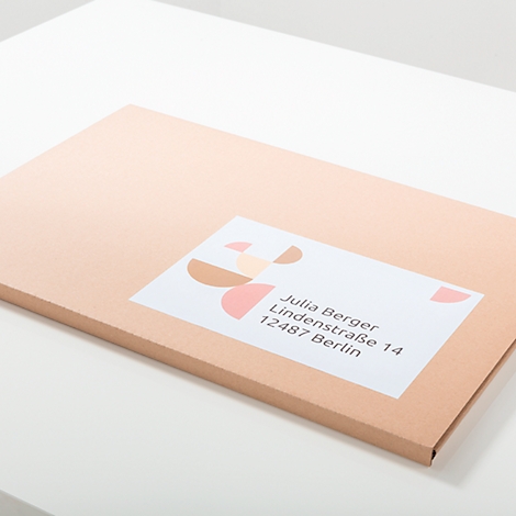 A beige envelope with a label. The label contains a name and address.