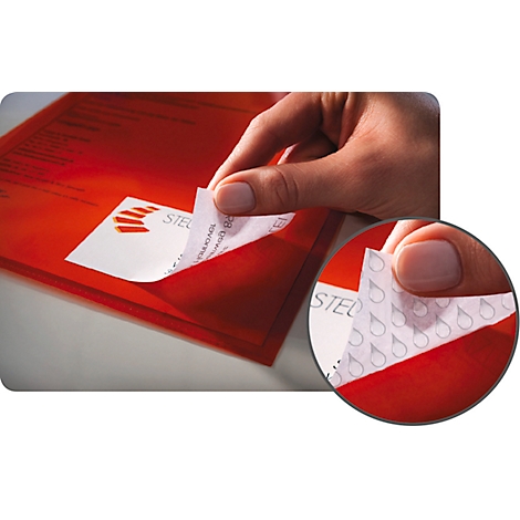Close-up of hand peeling a sticker from a red envelope. In detail: water droplet pattern.