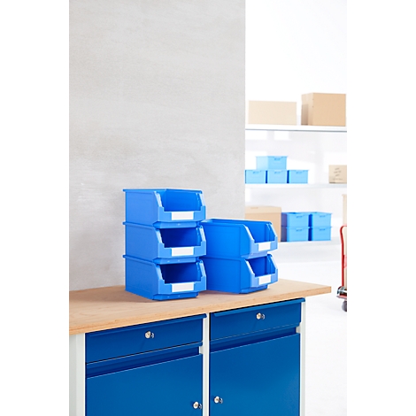 Boîtes de rangement bleues sur un établi. En arrière-plan, d'autres boîtes et une étagère.