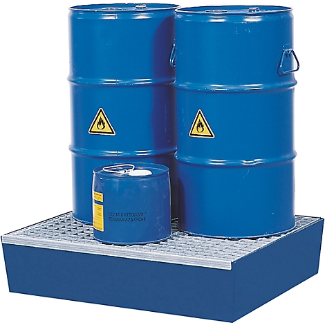 Des fûts bleus avec des panneaux d'avertissement jaunes sur une cuvette de rétention bleue.