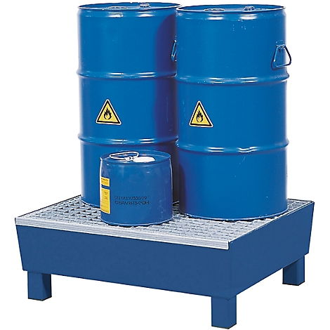 Barils bleus avec des panneaux de matières dangereuses sur une bac de rétention bleu.