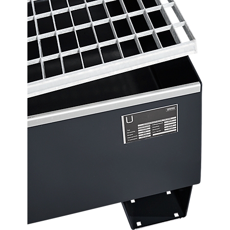 Récipient gris foncé avec grille métallique et plaque signalétique.