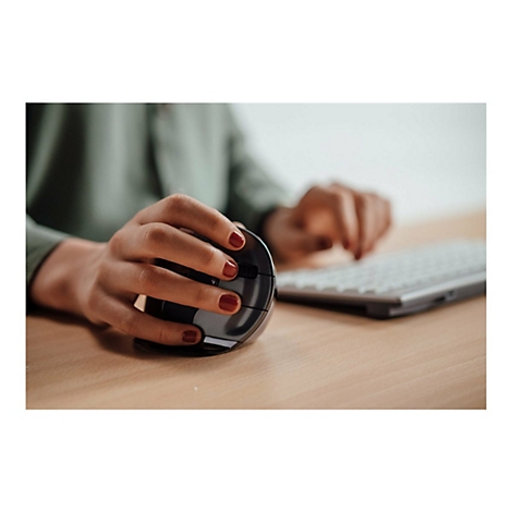 Person, die eine ergonomische Maus benutzt; rote Fingernägel auf Holzoberfläche. Eine Tastatur ist im Hintergrund.