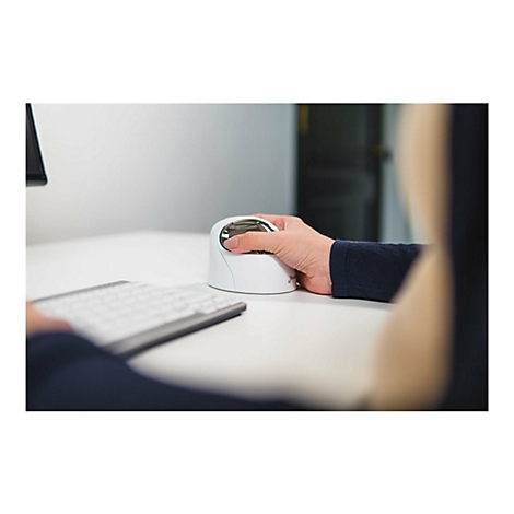 Person bedient vertikale Maus. Weiße Maus, silbernes Oberteil, auf weißem Tisch. Dunkler Pullover, Tastatur, heller Hintergrund.