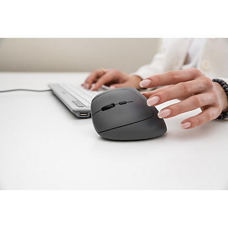 Eine Frau benutzt eine ergonomische Maus und Tastatur; der Fokus liegt auf der Hand am Maus.
