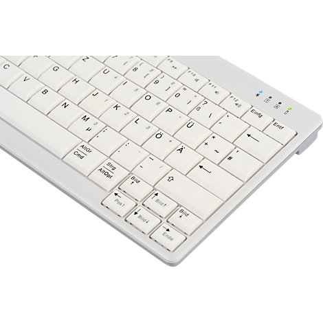 Rückseite einer dunklen Tastatur, die einen Aufkleber mit Produktinformationen zeigt. Auf der Rückseite sind Füße und Schalter angebracht.