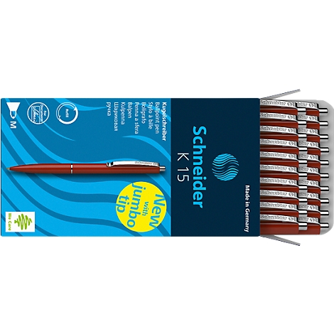 A red ballpoint pen lies next to a box containing more pens. The box displays the text "Schneider K 15".