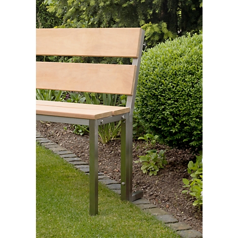 Banc de jardin moderne en bois et acier inoxydable. Espace vert en arrière-plan avec des buissons et des arbres.