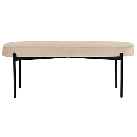 Beige gestoffeerde bank met zwarte metalen poten. De zitting is ovaal van vorm.