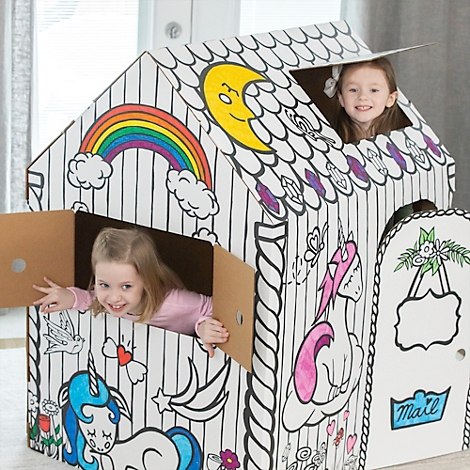 Zwei Mädchen spielen in einem bemalten Spielhaus. Das Haus hat ein Regenbogen-, Einhorn- und Mond-Design. Die Kinder lächeln.