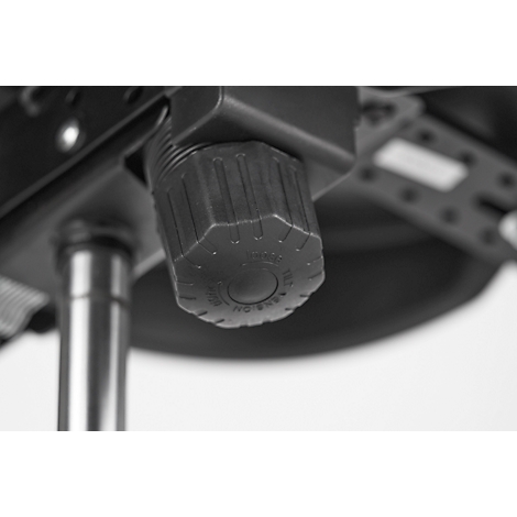 Detail of a black wheel under a chair with lettering.