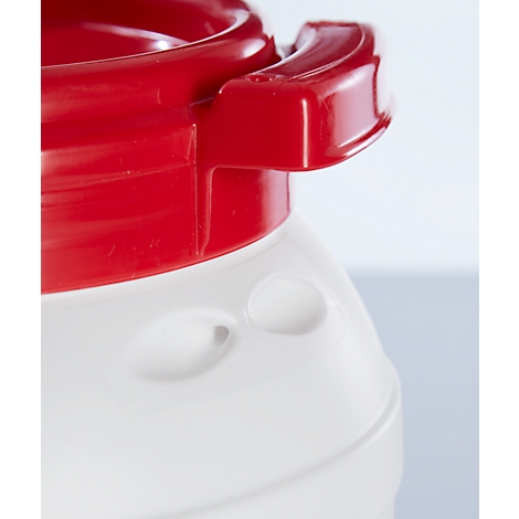 Gros plan d'une poignée rouge sur un récipient blanc, qui semble faire partie d'un produit plus grand.