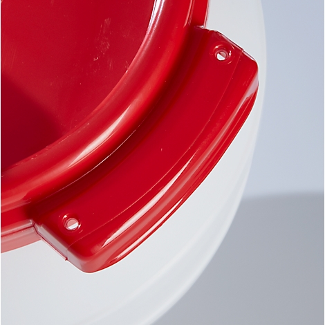 Gros plan d'une poignée rouge sur un récipient blanc, deux trous.