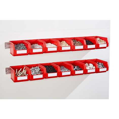 Étagères murales rouges avec de petits compartiments remplis de divers objets, tels que des pierres ou des vis.