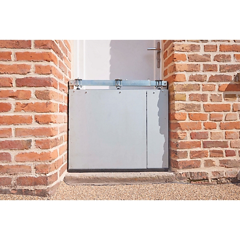 Blocage de porte gris entre des murs en briques. Au-dessus de la porte se trouve un support métallique.