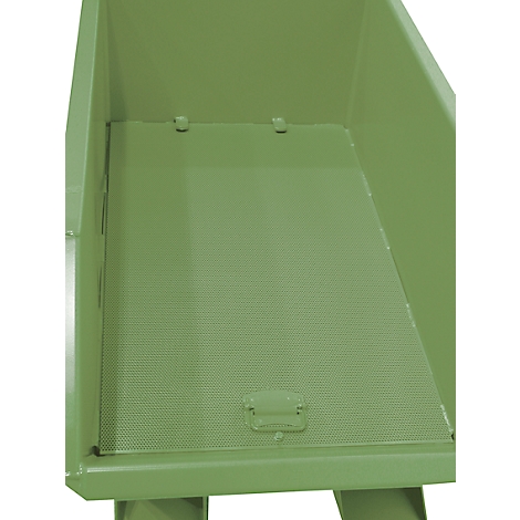 Brouette vert clair et vide avec des perforations dans le fond. La poignée d'un volet est visible en bas au centre.