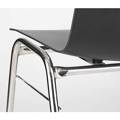 Close-up of a chair with a black seat and a chrome frame. The shapes are organic.