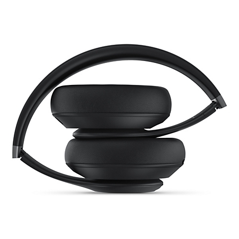 Un casque noir plié reposant sur un fond blanc.