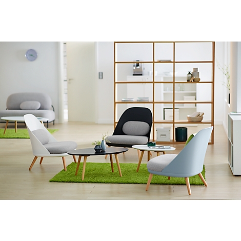 Wohnzimmer mit modernen Möbeln: Stühle, Tische und grüner Teppich. Ein Regal und eine Couch im Hintergrund.