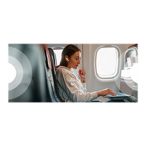 Jeune femme dans un avion, portant un casque et utilisant un ordinateur portable. Elle est assise prÃ¨s de la fenÃªtre.