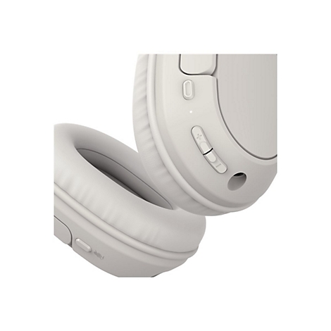 Gros plan sur un casque gris clair. On distingue l'écouteur et les commandes de volume et de mise sous tension.