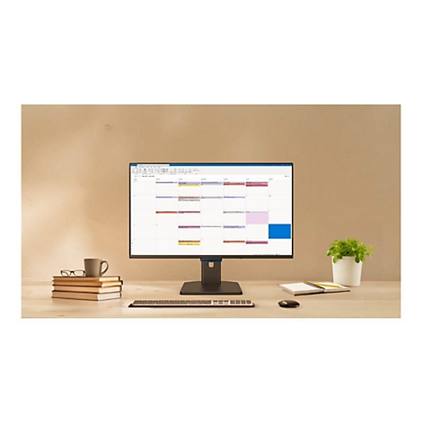 Ein Computermonitor auf einem Schreibtisch zeigt einen Kalender. Daneben stehen Bücher, eine Kaffeetasse und eine Pflanze.