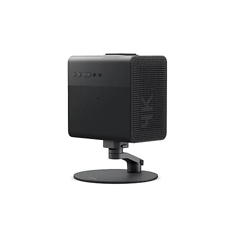 Schwarzer Projektor auf einem Ständer, vorne Knöpfe. Gitter auf der Seite. Neutraler Hintergrund.